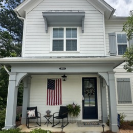 a cozy cottage house with an American flag
