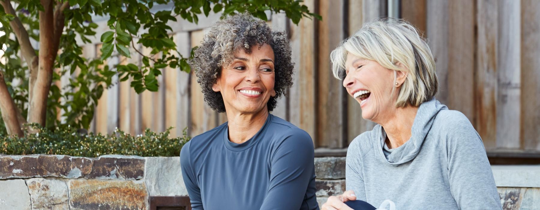 a couple of women sitting and laughing