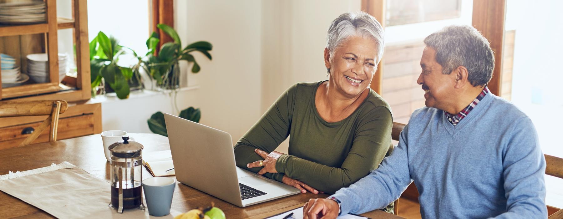 a man and a woman looking at a laptop